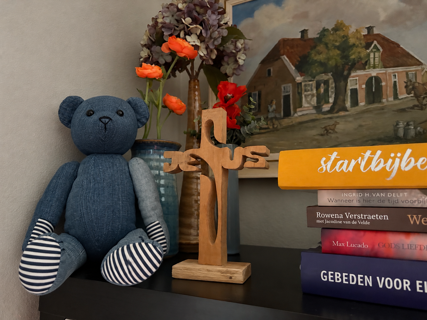 Beer naast een houten kruis en bloemen